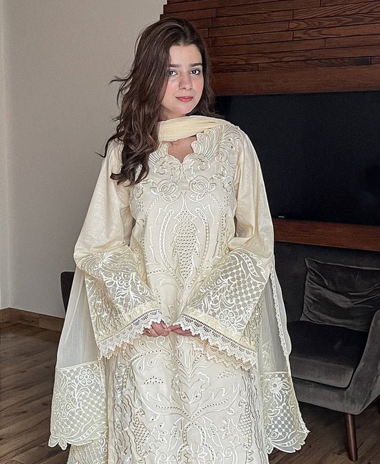 Model wearing Iznik 3-piece heavy embroidered off-white lawn suit with organza dupatta and lace trousers lubaba luxury.
