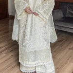 Model wearing Iznik 3-piece heavy embroidered off-white lawn suit with organza dupatta and lace trousers lubaba luxury.