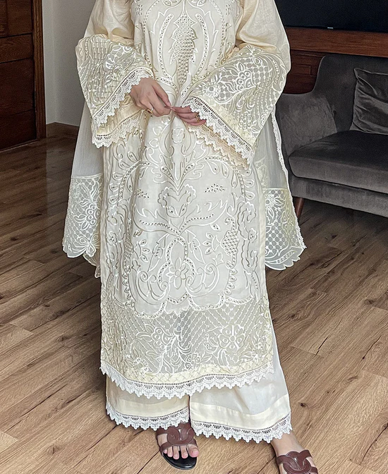 Model wearing Iznik 3-piece heavy embroidered off-white lawn suit with organza dupatta and lace trousers lubaba luxury.
