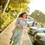 Woman wearing a Minha 3-piece grip silk suit in pastel blue with pink floral embroidery and a matching chiffon dupatta lubaba luxury.