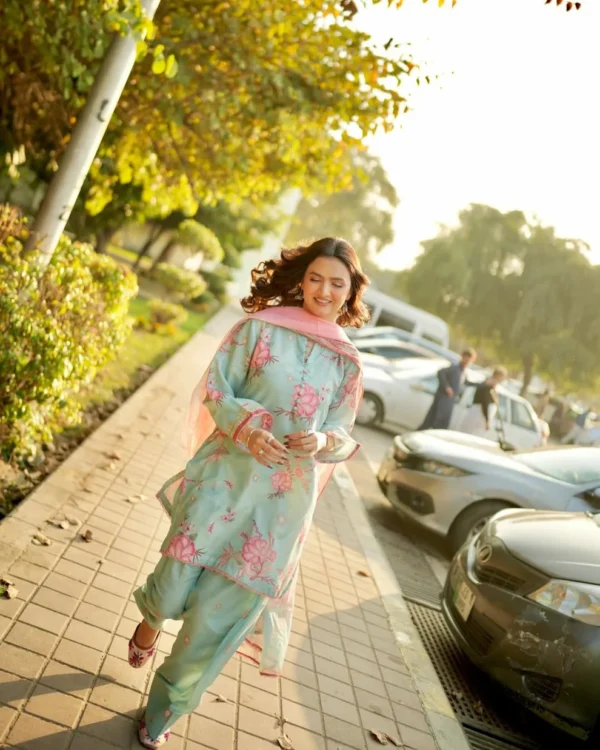 Woman wearing a Minha 3-piece grip silk suit in pastel blue with pink floral embroidery and a matching chiffon dupatta lubaba luxury.