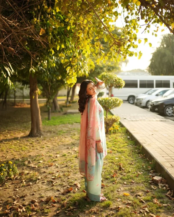 Woman wearing a Minha 3-piece grip silk suit in pastel blue with pink floral embroidery and a matching chiffon dupatta lubaba luxury.