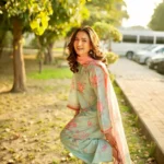 Woman wearing a Minha 3-piece grip silk suit in pastel blue with pink floral embroidery and a matching chiffon dupatta lubaba luxury.