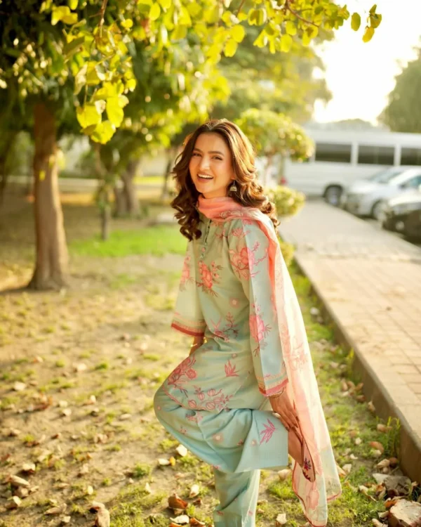 Woman wearing a Minha 3-piece grip silk suit in pastel blue with pink floral embroidery and a matching chiffon dupatta lubaba luxury.