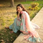 Woman wearing a Minha 3-piece grip silk suit in pastel blue with pink floral embroidery and a matching chiffon dupatta lubaba luxury.