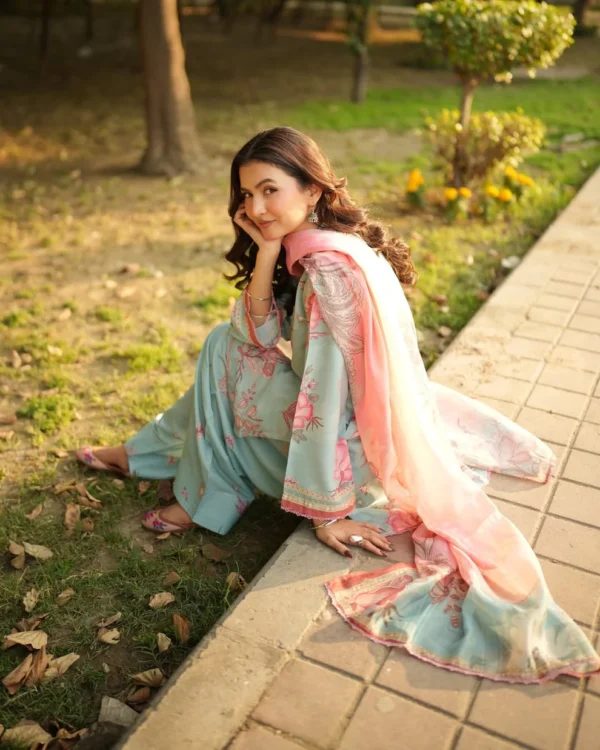 Woman wearing a Minha 3-piece grip silk suit in pastel blue with pink floral embroidery and a matching chiffon dupatta lubaba luxury.