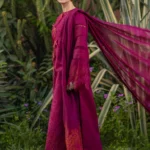 Model wearing Rang Rasiya Ayra unstitched luxury lawn 3-piece suit in plum with embroidered chikan shirt and khaddi net dupatta lubaba luxury.