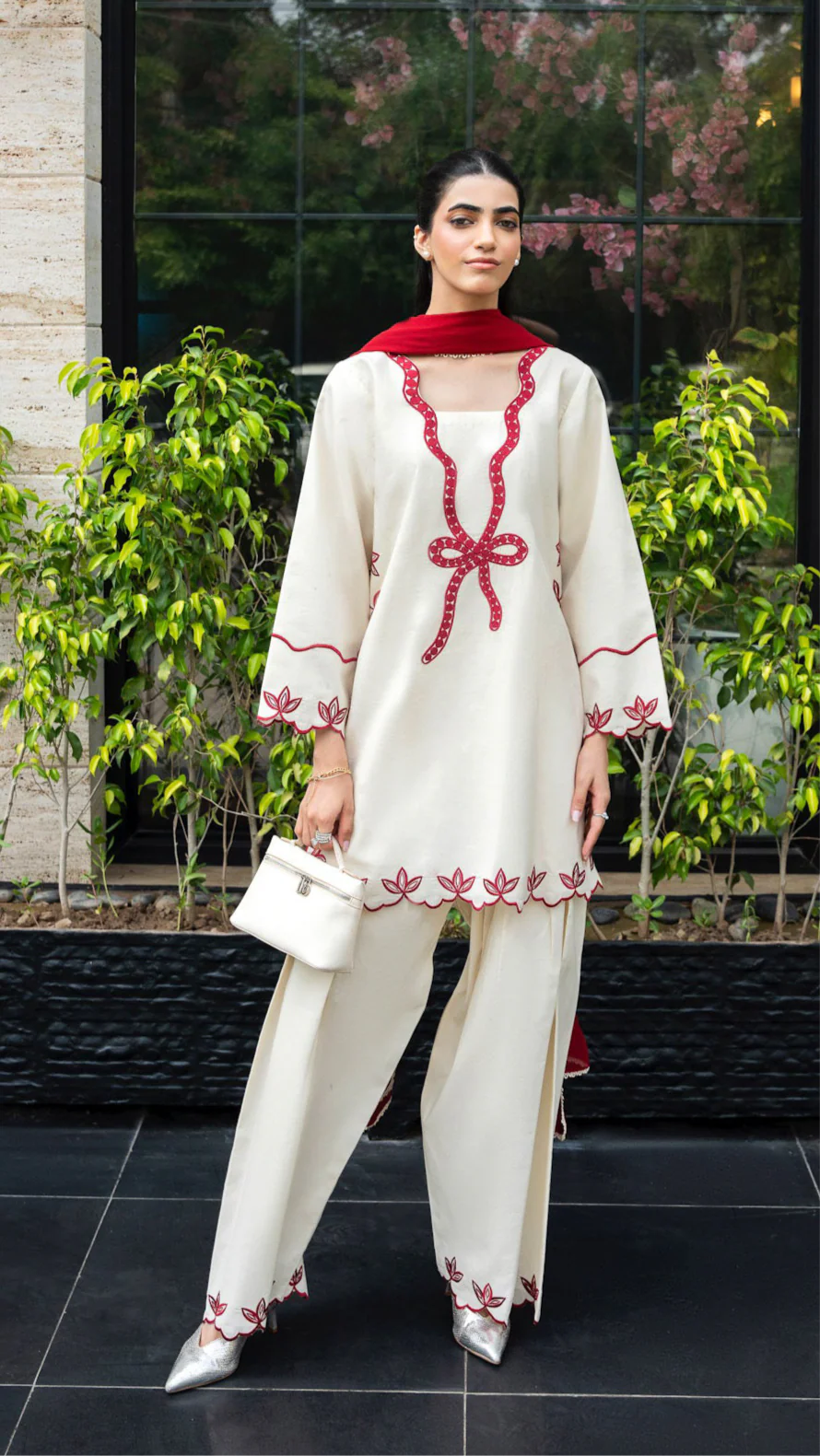 Ivory cotton Pakistani 3-piece suit with red bow embroidery and red dupatta by Lubaba Luxury.