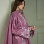 Model wearing a mauve Cross Stitch Orchid Glaze 3-piece embroidered lawn suit with a matching dupatta lubaba luxury.