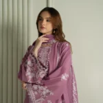 Model wearing a mauve Cross Stitch Orchid Glaze 3-piece embroidered lawn suit with a matching dupatta lubaba luxury.