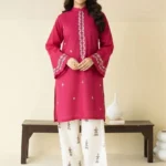 Close-up of Magenta embroidered lawn shirt with white threadwork and matching trousers.